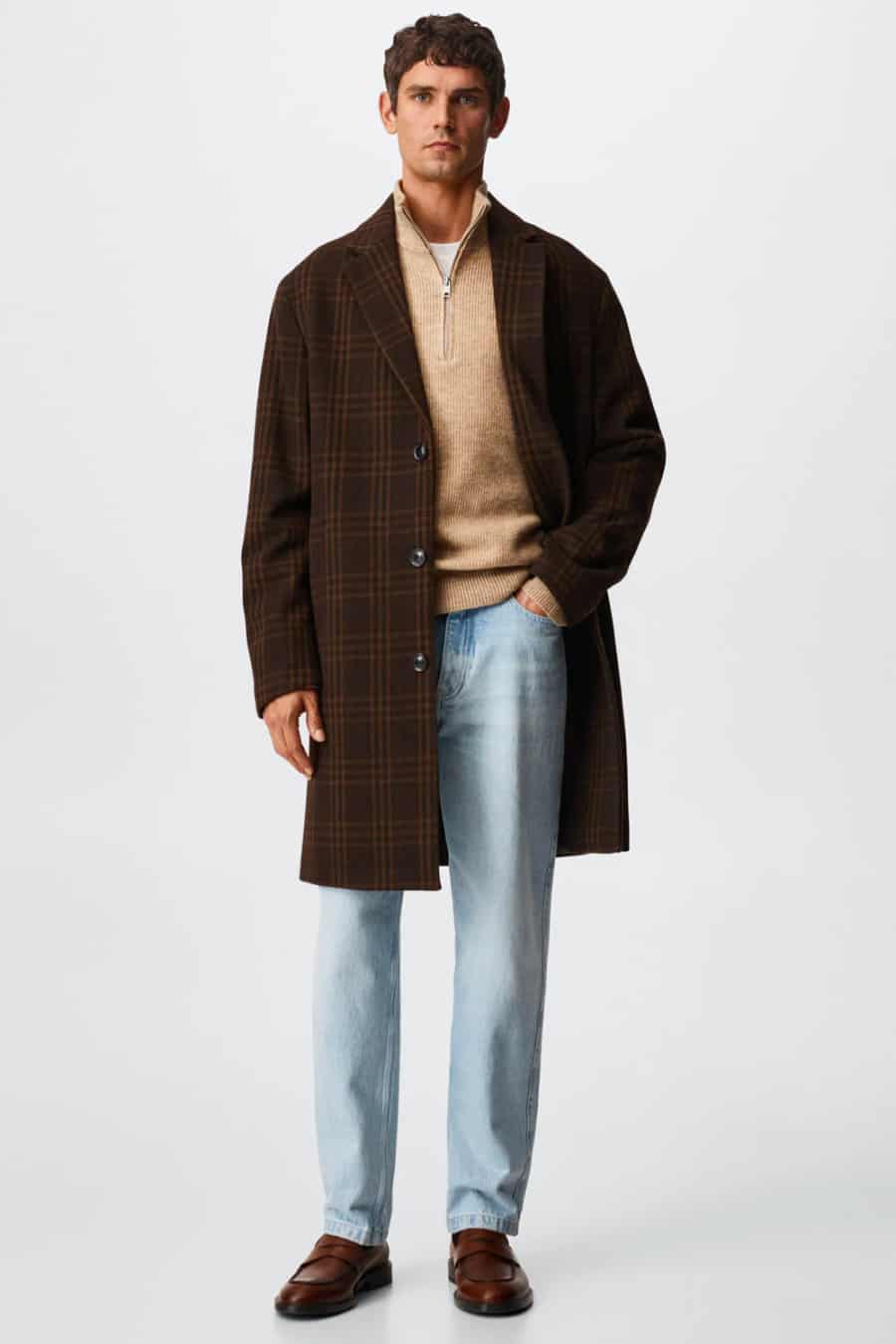 Men's light wash jeans, camel zip neck sweater, brown check overcoat and penny loafers outfit