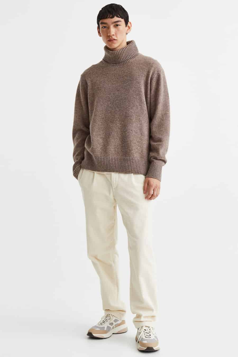 Men's off-white relaxed trousers, chunky brown roll neck jumper and running sneakers outfit