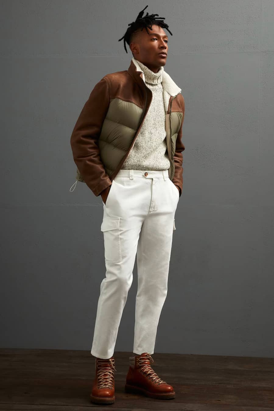 Men's white cargo pants, chunky ecru turtleneck, padded puffer jacket and brown hiking boots outfit