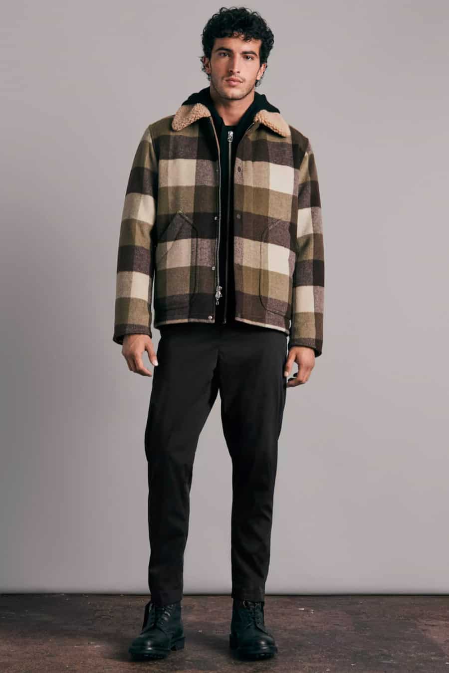 Men's black chinos, black hoodie, checked wool sherpa jacket and black boots outfit