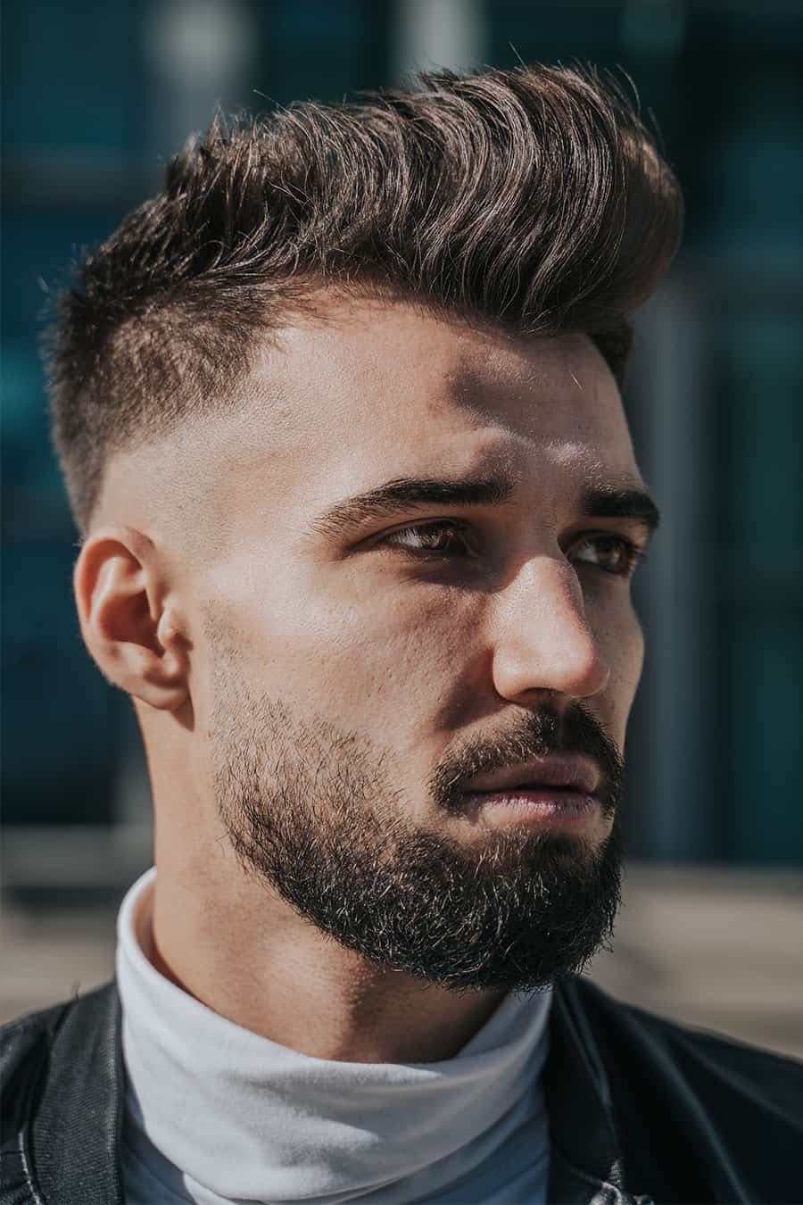 Men's high pompadour haircut with mid bald fade