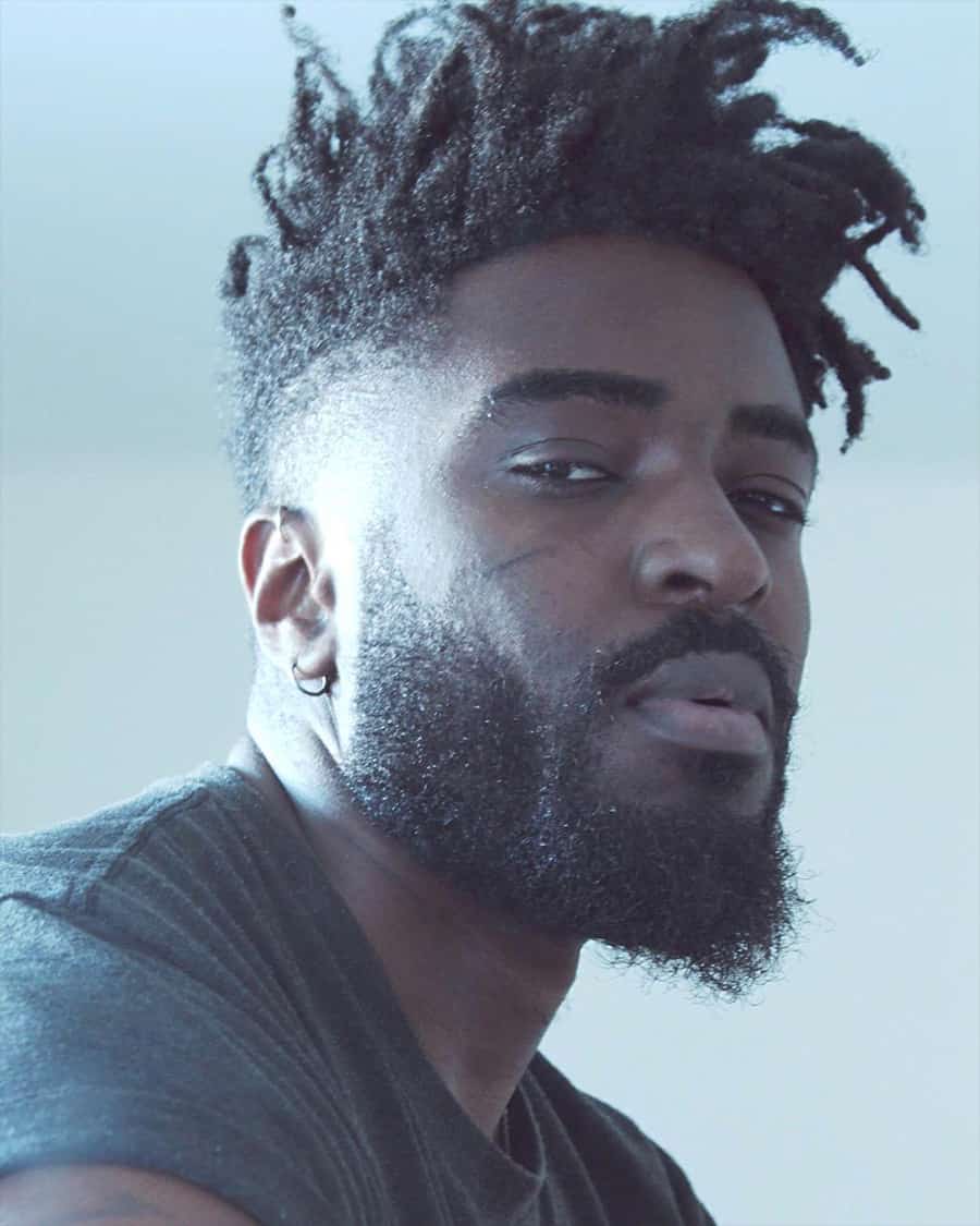 Black man with short dreads/twists and a high skin fade