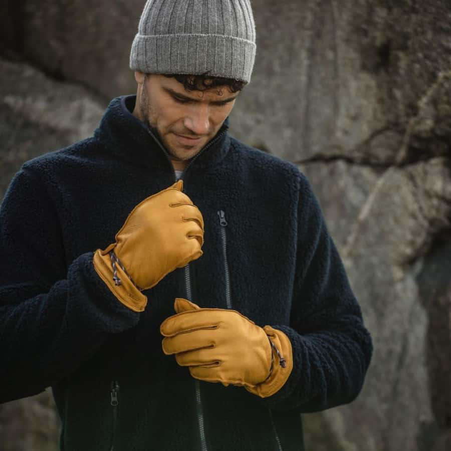 Man wearing a fleece, beanie and insulated yellow gloves