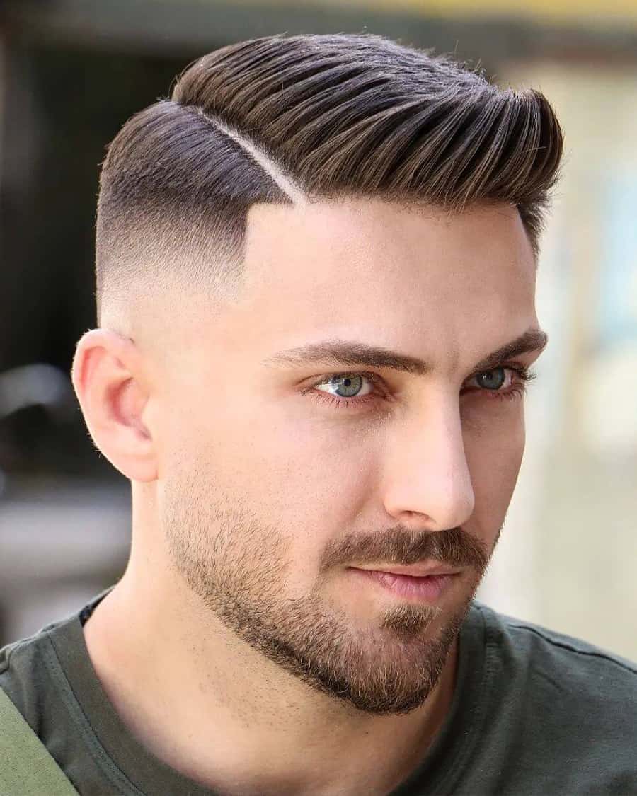 Man with slick quiff hairstyle, hard parting and high bald fade
