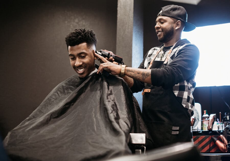 Black man cutting a high fade haircut in a barbershop