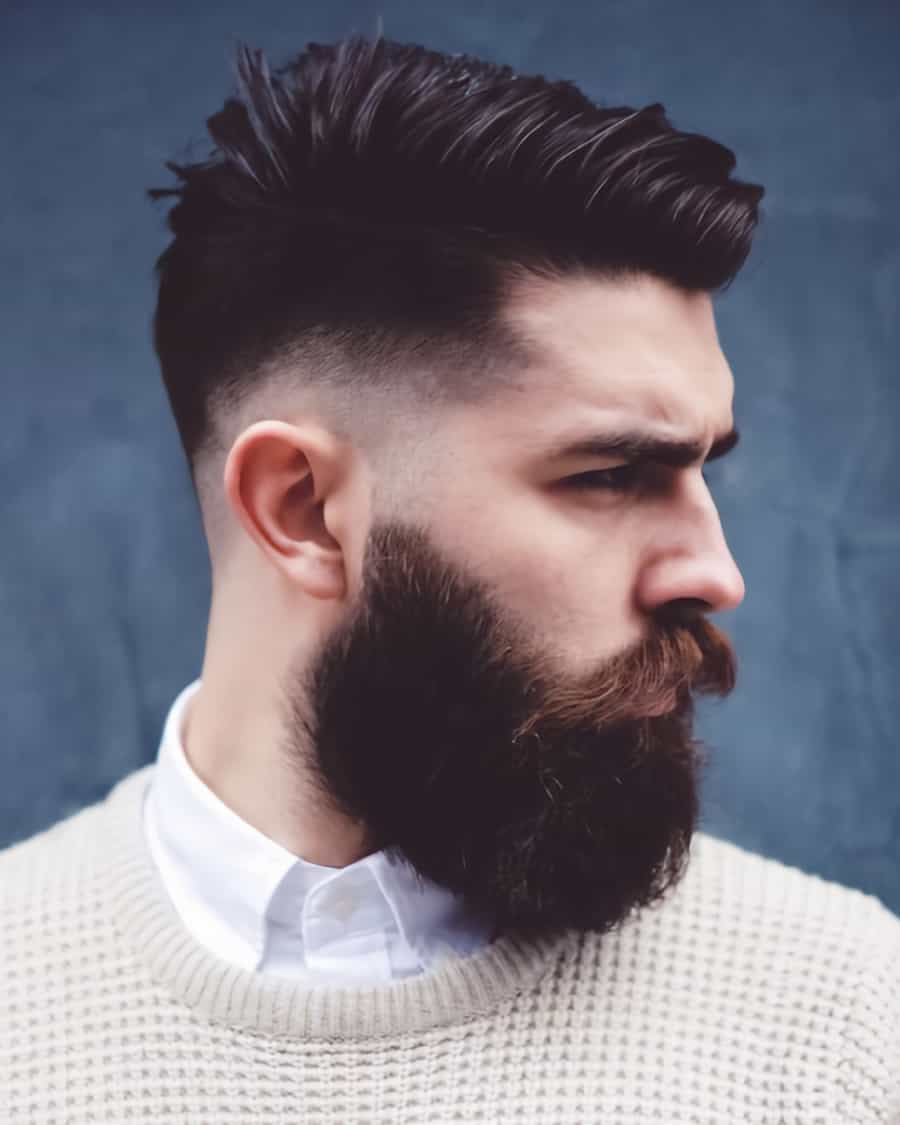 Men's sleek black quiff haircut with mid-to-low bald fade