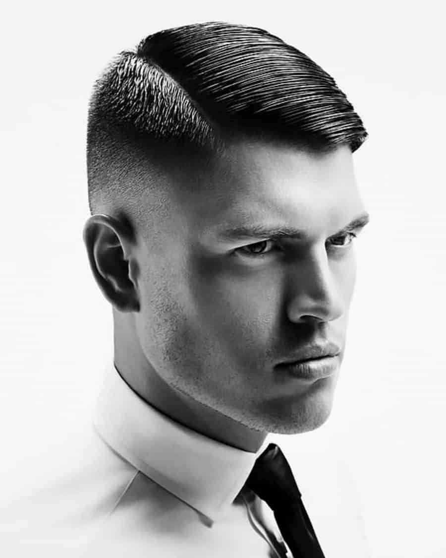 Man with military slick side parting hairstyle and mid bald fade