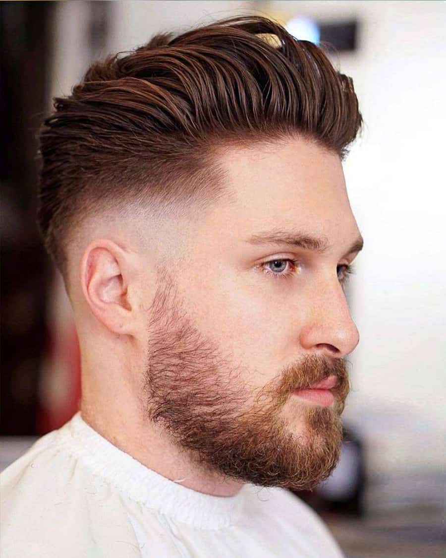 Men's sleek pompadour hairstyle with low skin fade