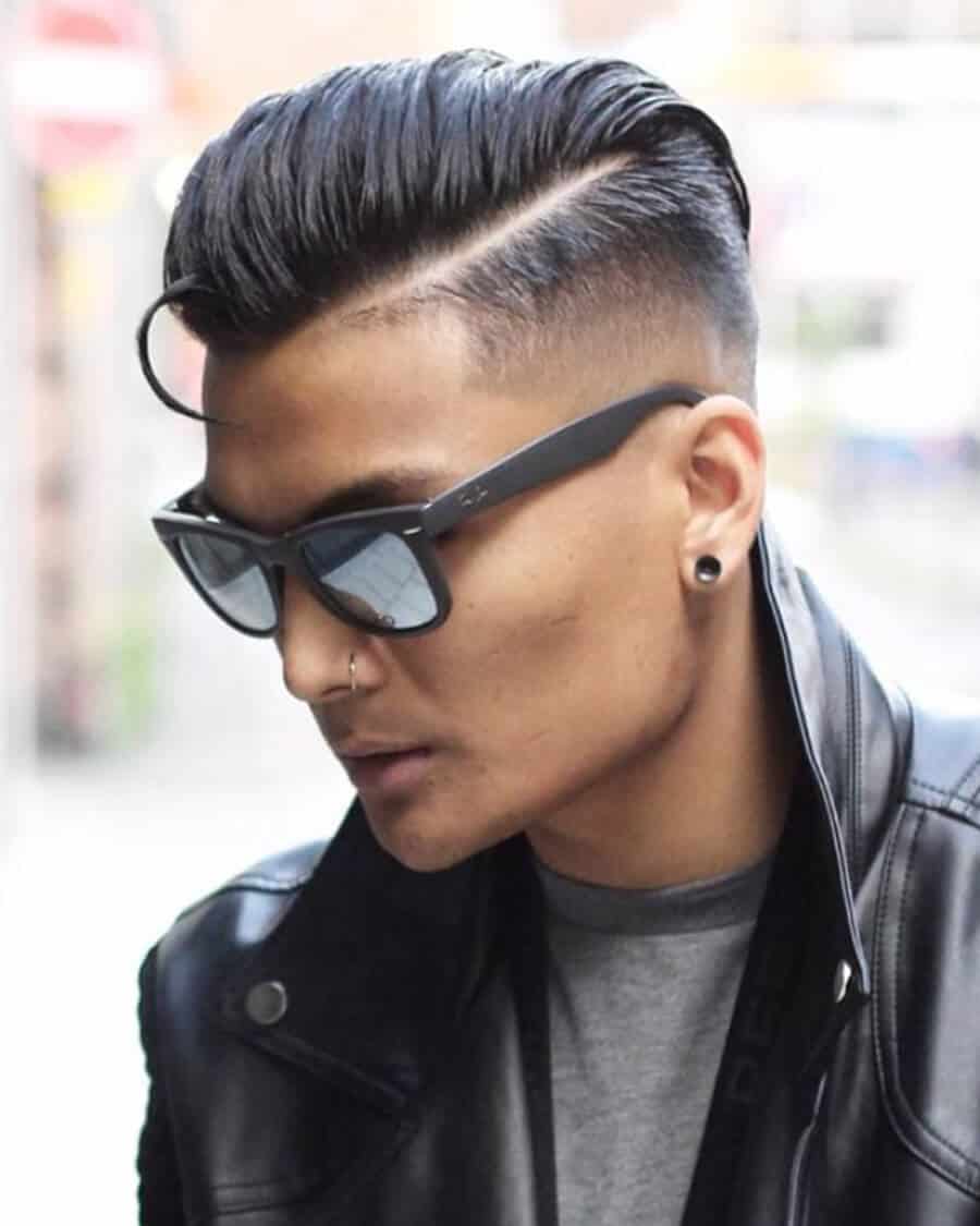 Man with slicked back hair, undercut and bald fade
