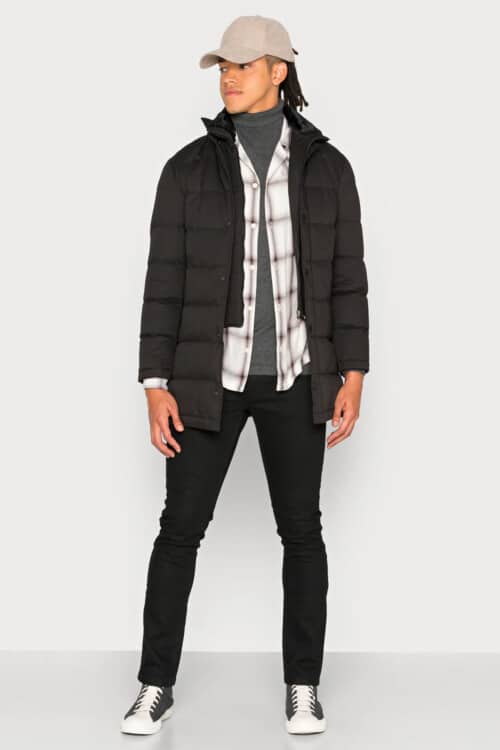Men's black jeans, grey turtleneck, check flannel shirt, black puffer jacket, baseball cap and sneaker boots outfit