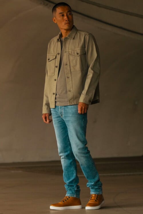 Men's light blue jeans, khaki T-shirt, khaki overshirt and brown sneaker boots outfit