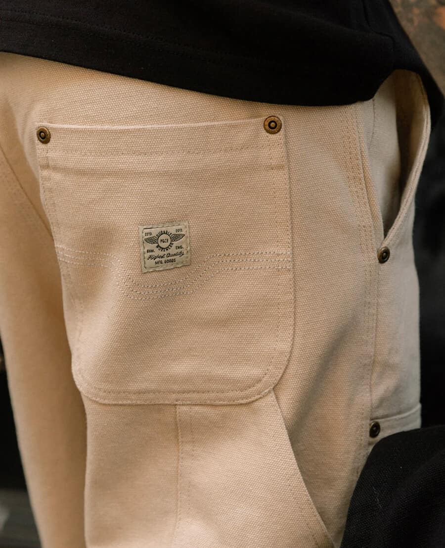 The back pocket of a pair of cream men's carpenter pants