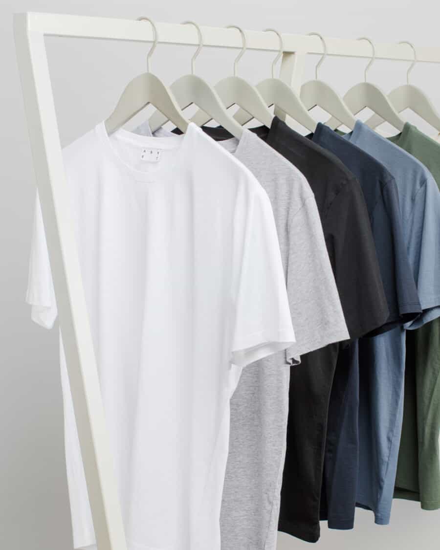 A selection of heavyweight men's T-shirt hanging on a clothes rail in multiple colours