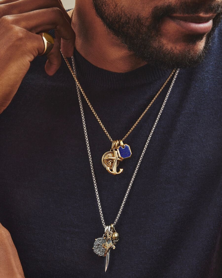 Man wearing two chain pendant necklaces of different lengths