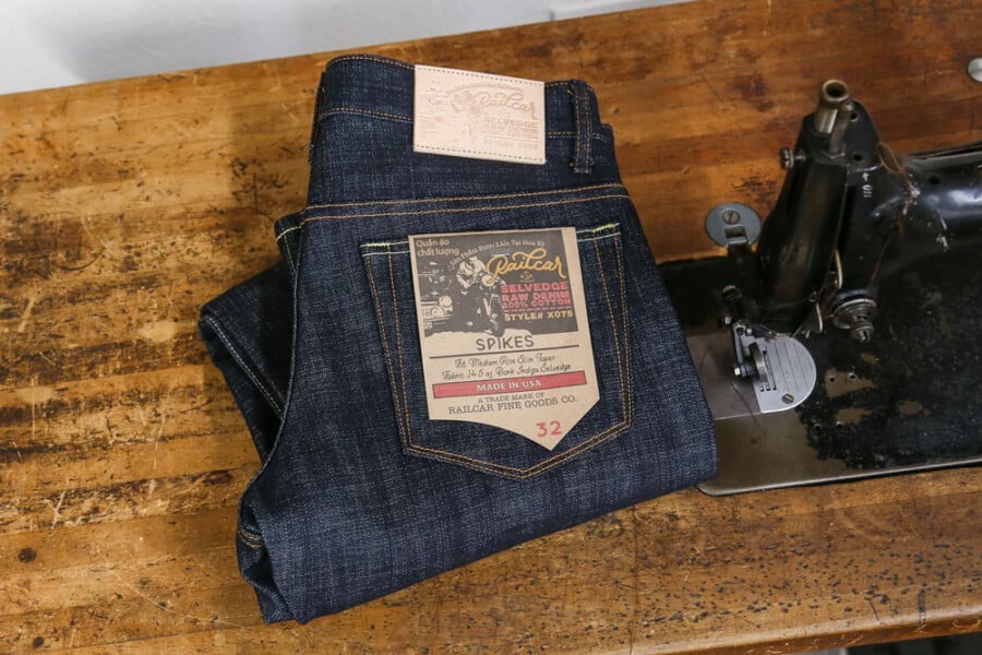 A pair of Railcar Fine Goods American-made men's jeans folded on a work bench