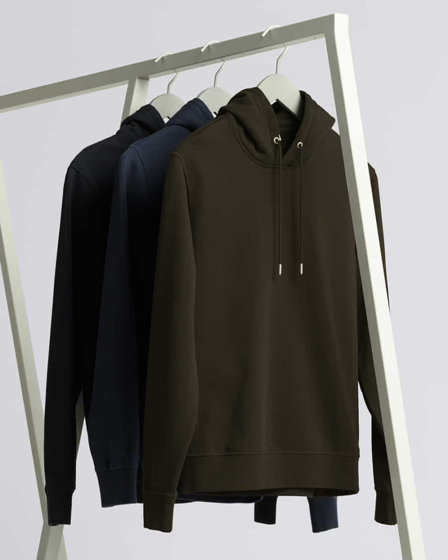 Three heavyweight hoodies hanging on a clothes rail
