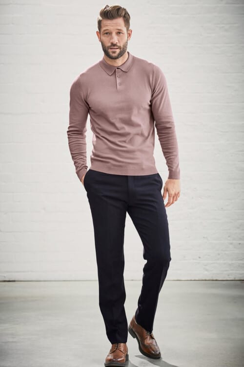 Men's navy trousers, long sleeve pink knitted polo shirt and tan brown brogues