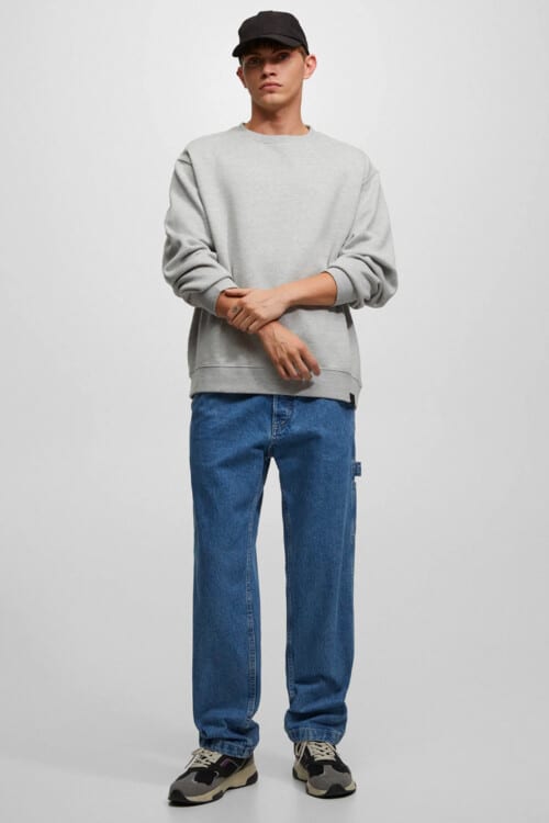 Men's loose carpenter jeans, grey sweatshirt, baseball cap and chunky sneakers outfit