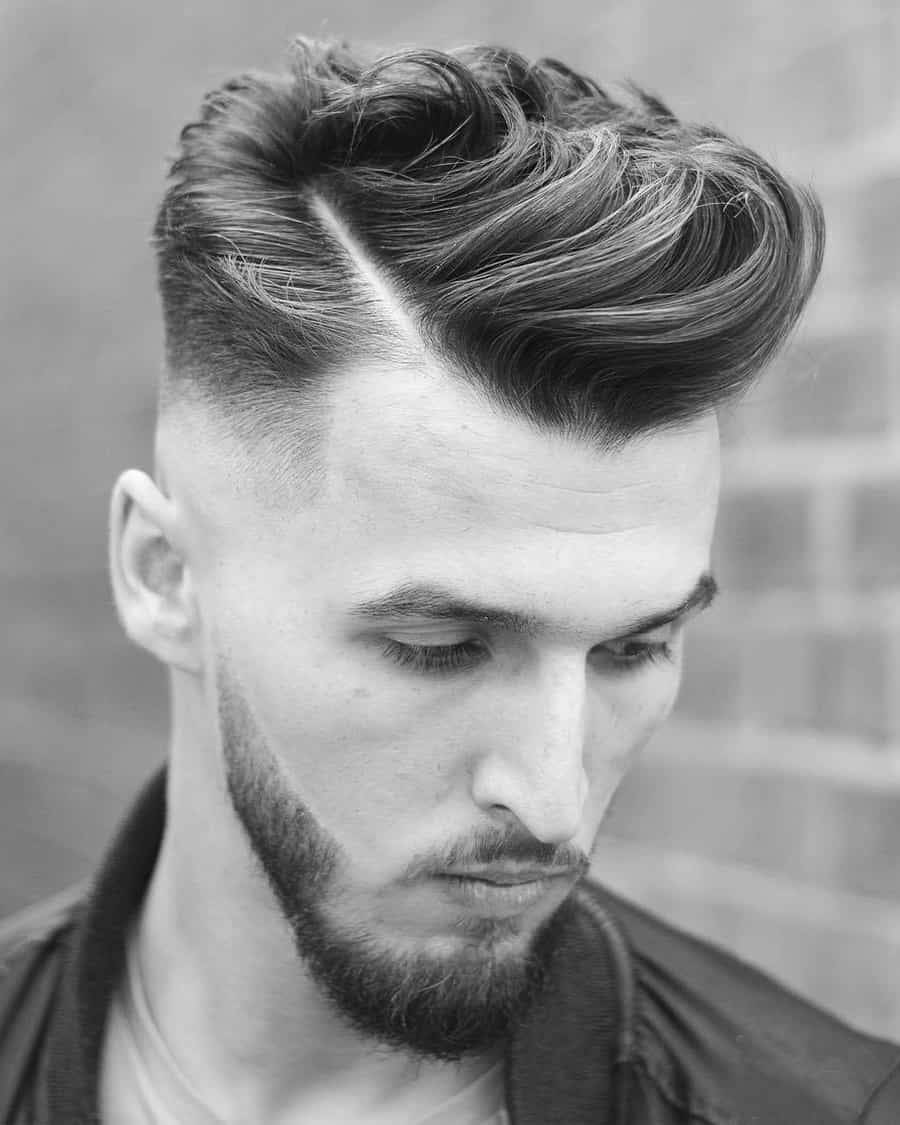 Men's long wavy comb over haircut with high skin fade