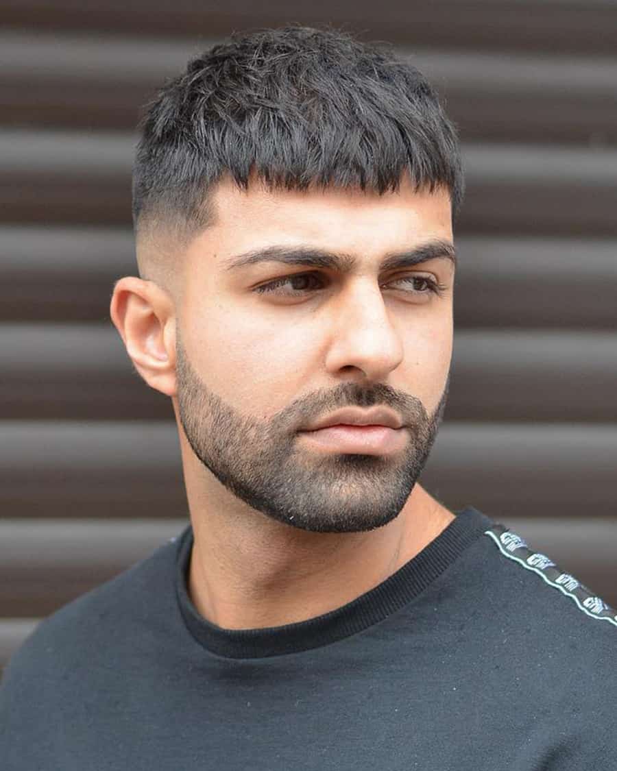 Man with a classic French crop hairstyle and mid skin fade