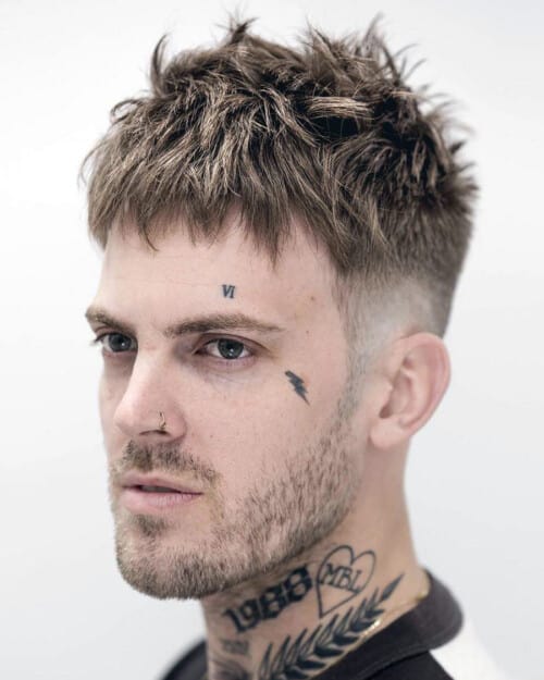 Men's messy, spiky French crop hairstyle with taper fade