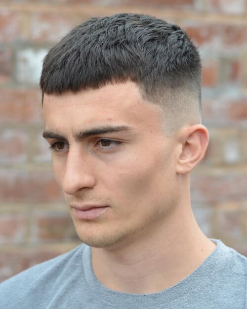 Man with a short French crop haircut and high fade