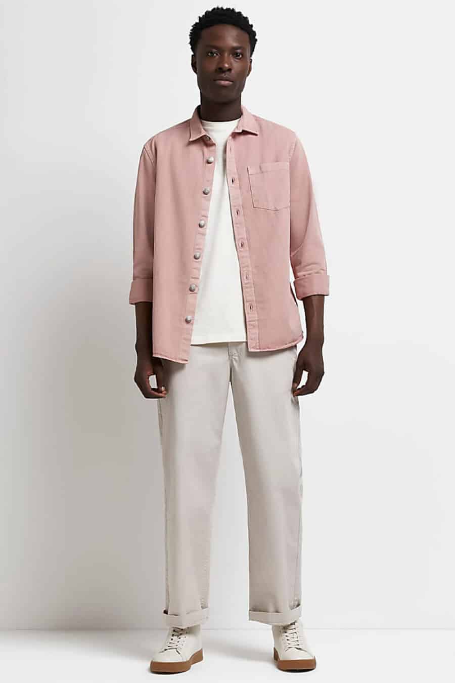 Men's wide leg grey chinos, white T-shirt, pink canvas overshirt and white sneakers outfit