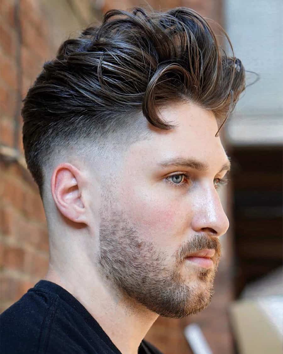Man with a high messy quiff and high taper fade haircut