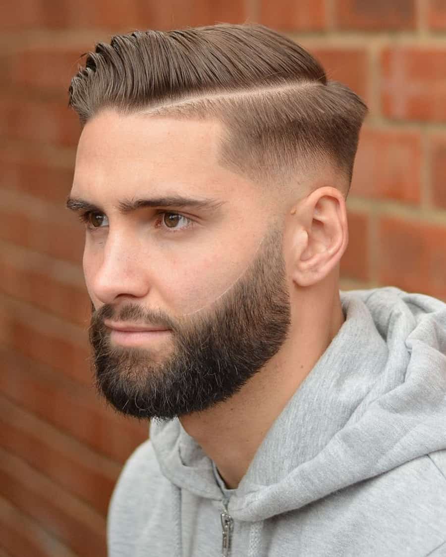 Man with slick side sweep hair, a hard parting and a high taper fade