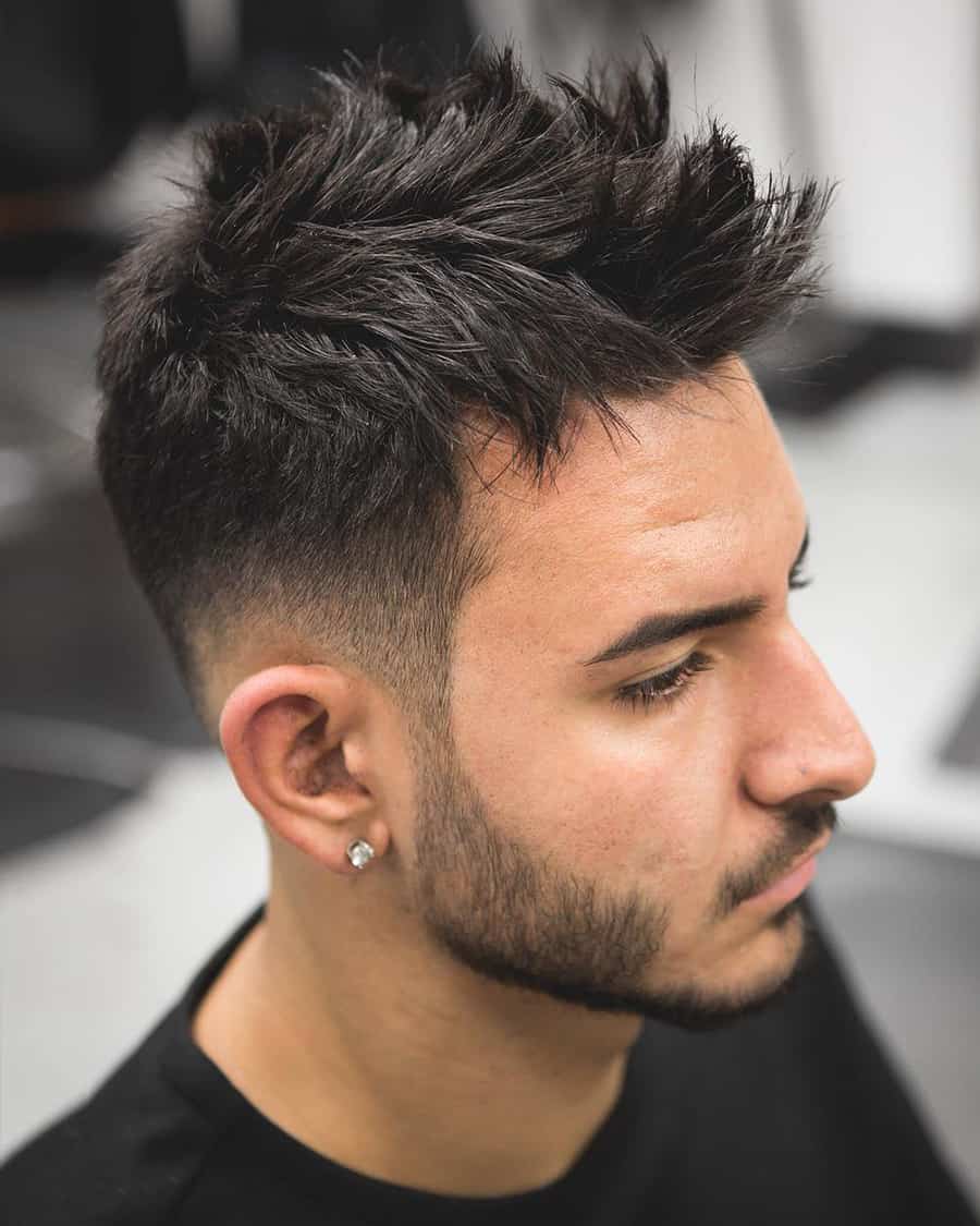 Man with spiky, mid-length black hair and a high taper fade haircut