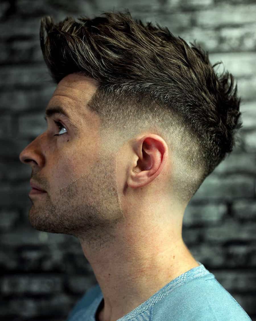 Man with pushed up, textured mid-length hair and a high taper fade