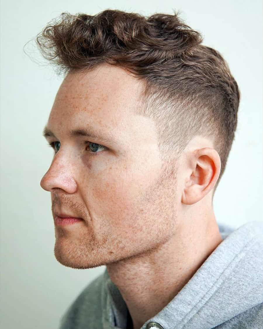 Man with short messy wavy hair and a high taper fade haircut