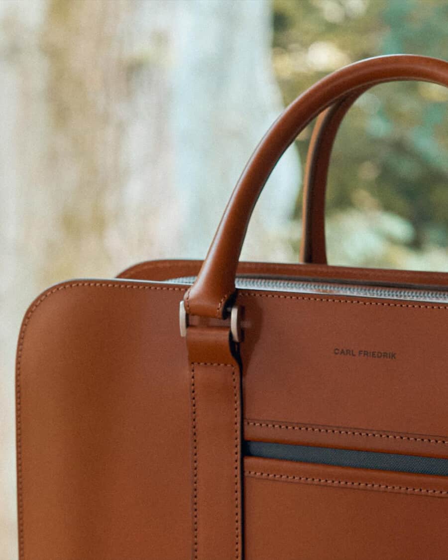 Close up of the stitching on the handles of a luxury Carl Friedrik tan leather bag