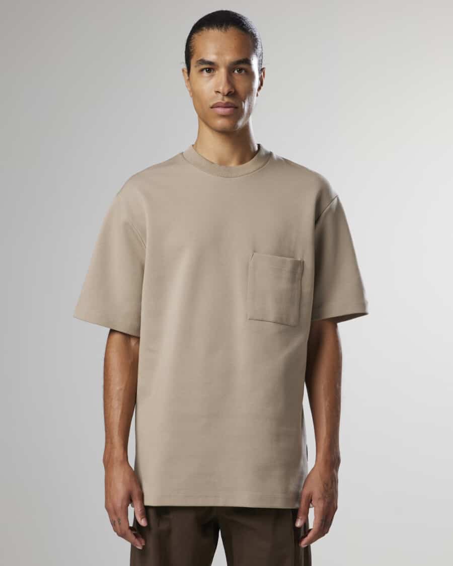 Man wearing a taupe heavyweight pocket T-shirt with brown pants