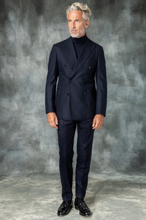 Men's semi-formal navy double-breasted suit worn with a navy roll neck and black leather loafers