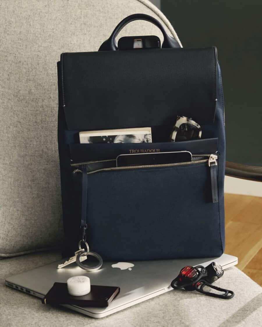 Luxury men's blue backpack on a chair with a macbook