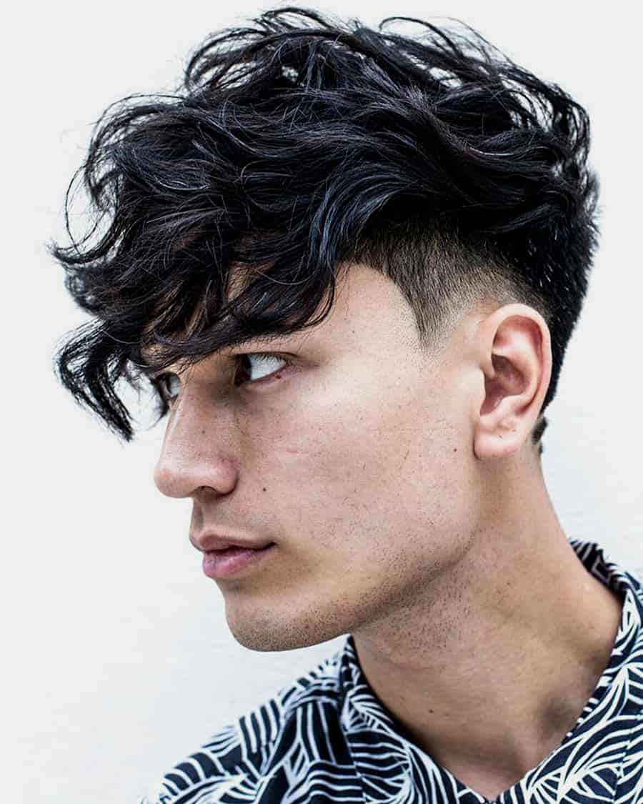 Men's long, messy wavy black hair with a temple fade