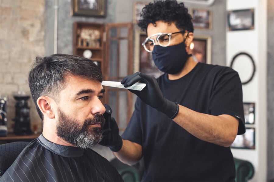A man in his 40s getting his haircut at a barbers