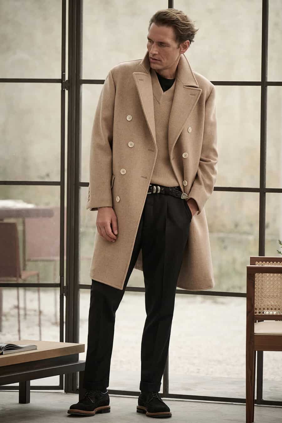 Men's black pleated trousers, camel v-neck sweater, camerl overcoat and suede brogues outfit
