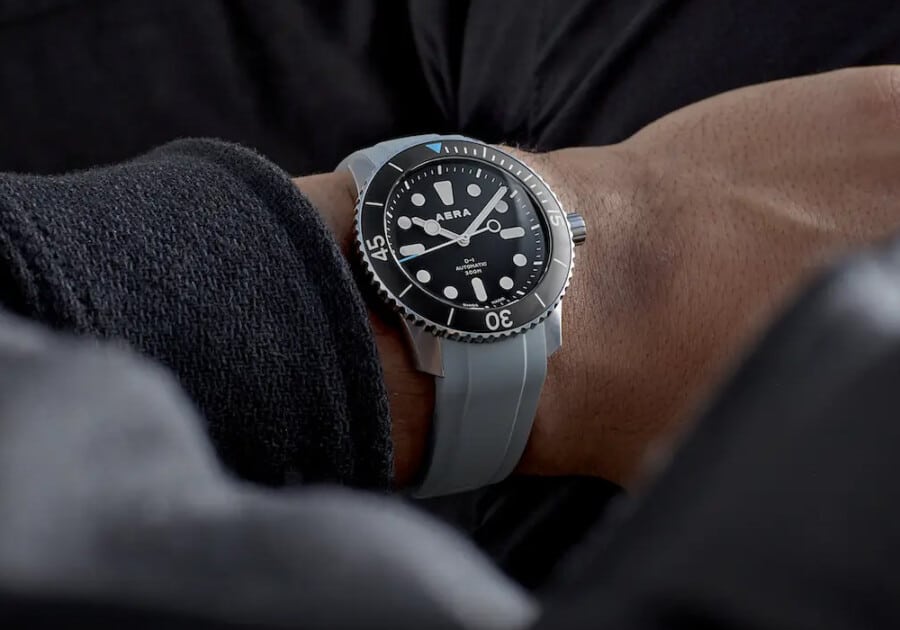 Man wearing a minimal Aera watch on wrist looking at time