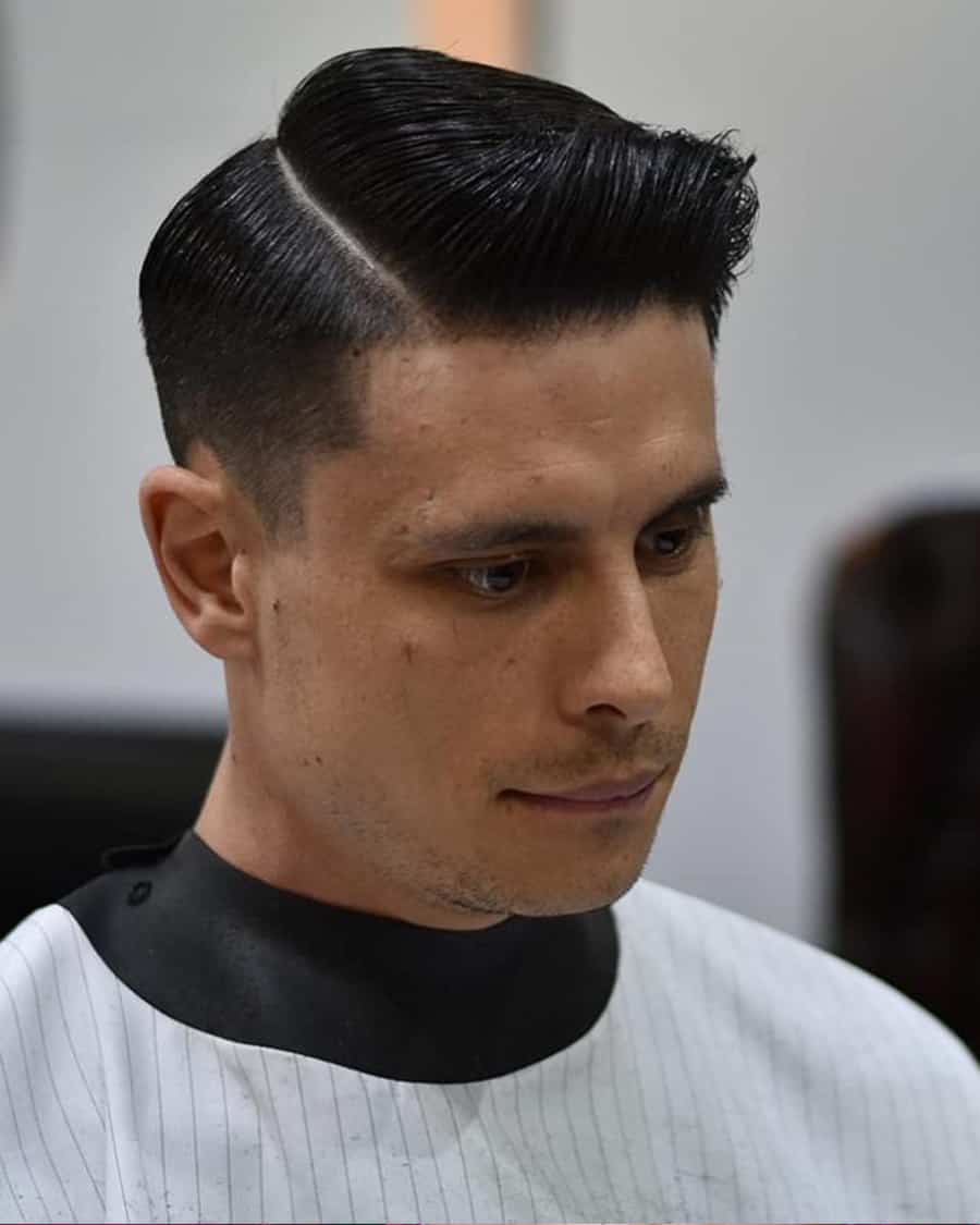 Men's slick side parting with quiff and taper fade