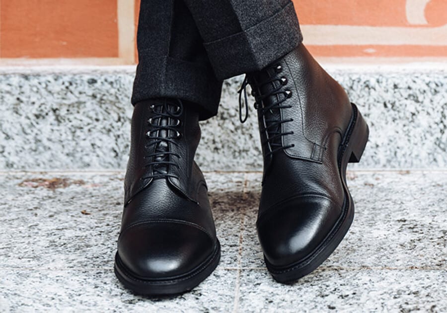 Man wearing black grained leather Derby boots with tailored black pants