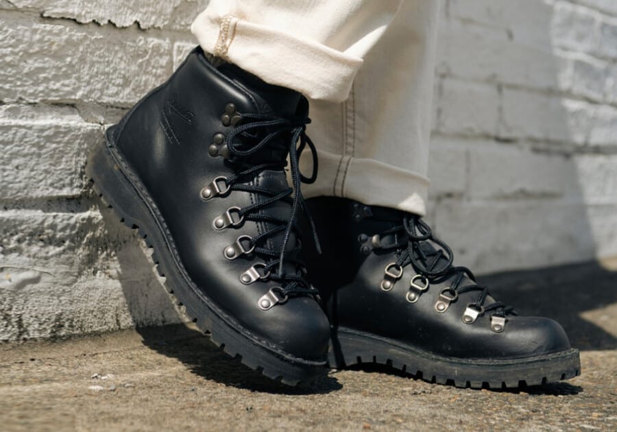 A pair of black leather classic hiking boots worn with off white jeans