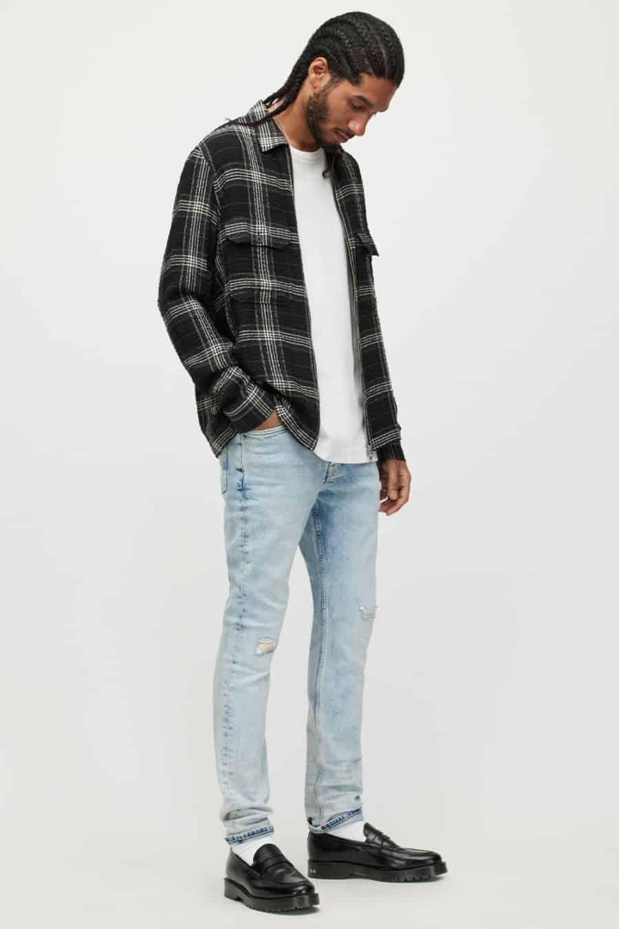 Men's light wash acid jeans, white T-shirt, checked flannel shirt and chunky black penny loafers with white socks outfit
