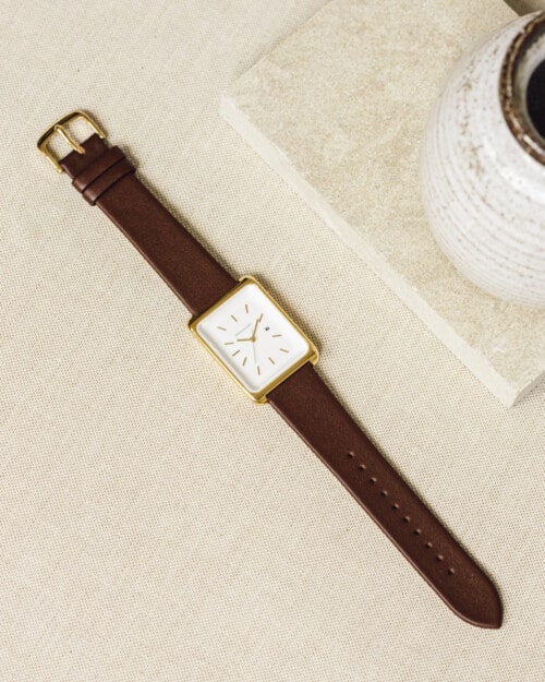 Monofore minimalist M01 gold watch 38mm with brown leather strap laid out on table