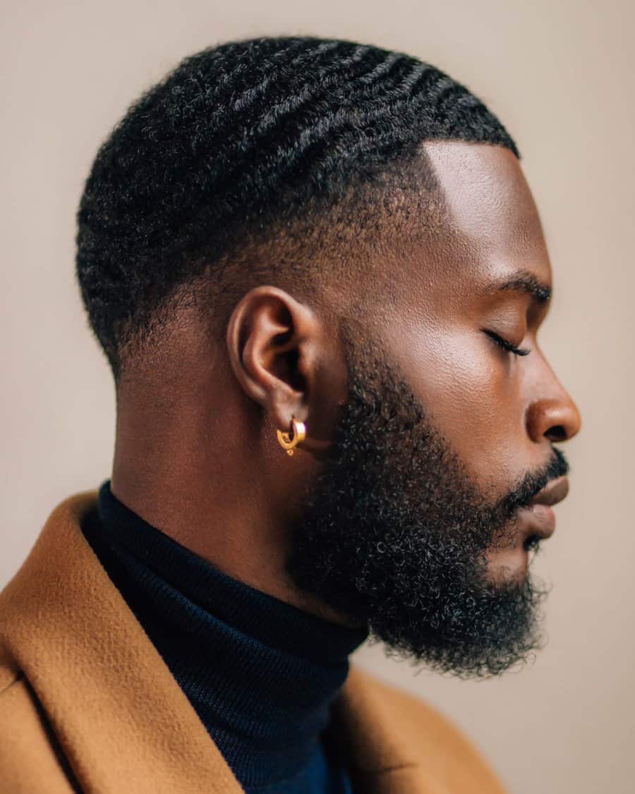 Black man with short, neat waves and a drop fade