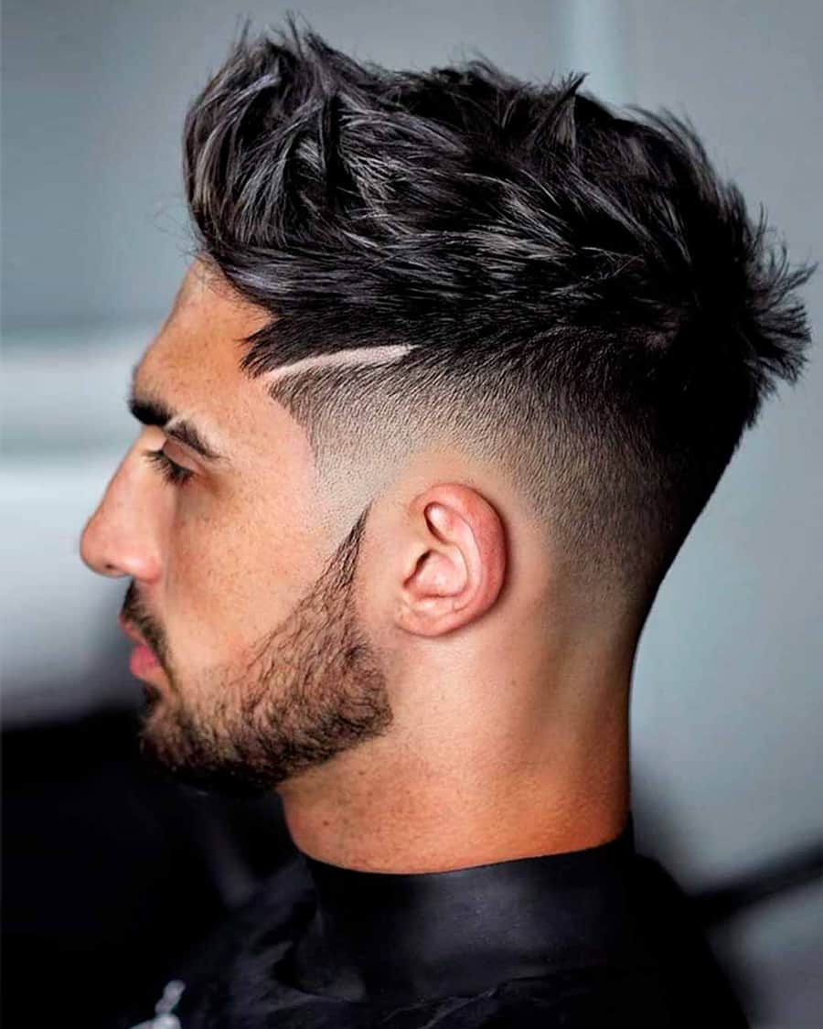 Men's lifted fringe haircut with drop fade and clipper line detailing