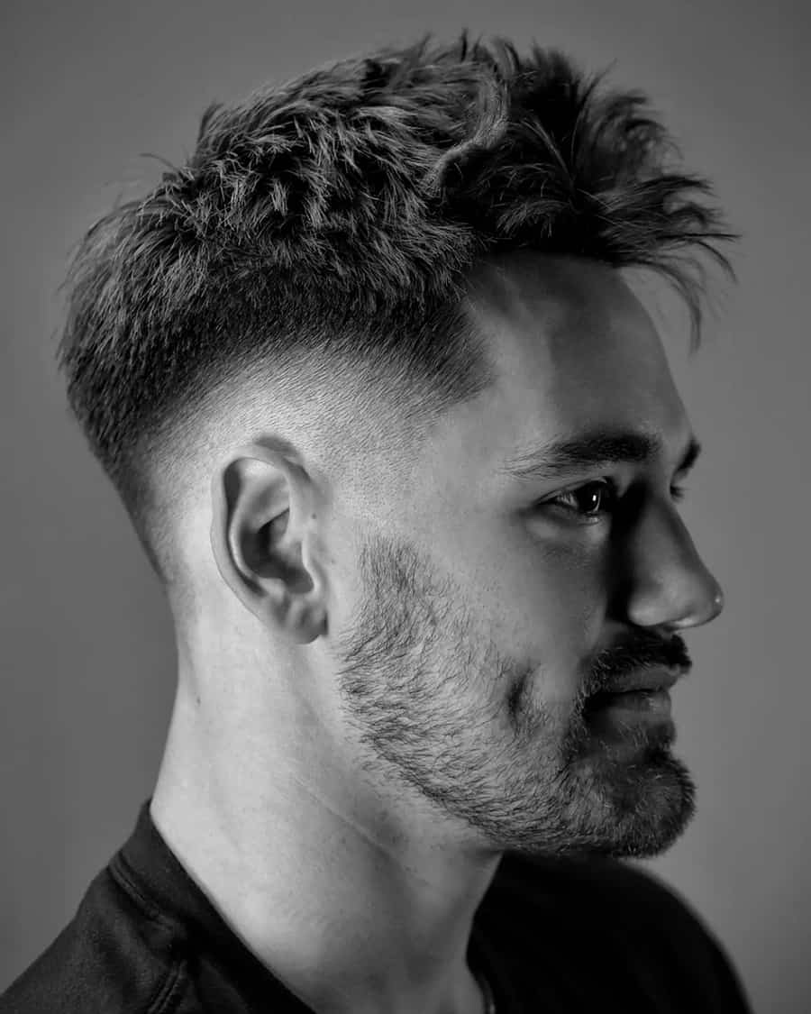 Men's short haircut with spiky, lifted fringe and drop fade