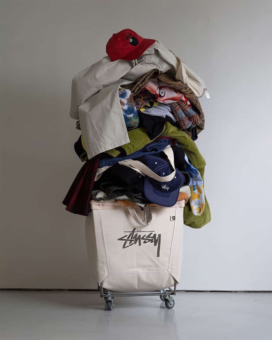 A selection of Stussy clothing piled high in a branded clothing basket