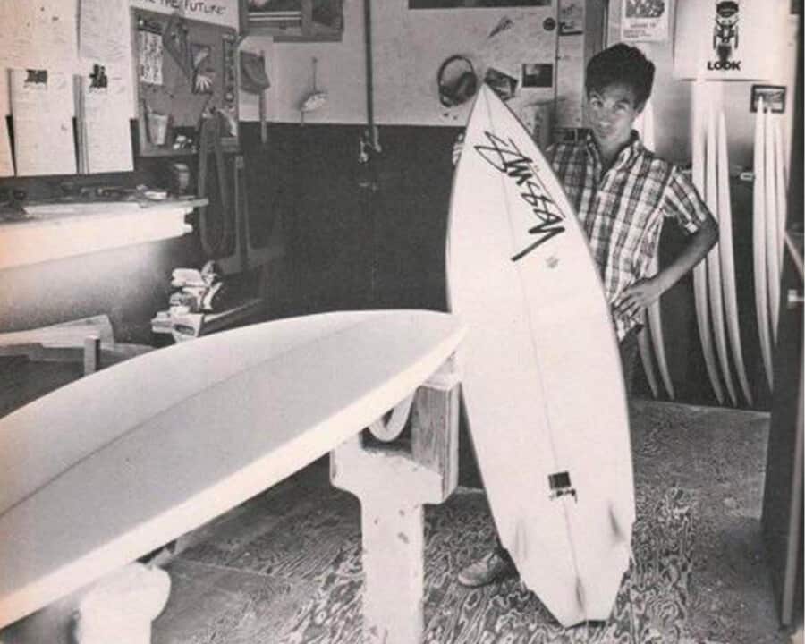 Shawn Stussy holding one of his original branded surf boards